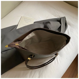 Intérieur spacieux d'un cabas en cuir marron avec doublure grise et fermeture dorée
