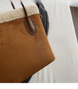 Détail du sac seau en daim marron avec bordure en sherpa blanc et anse en cuir