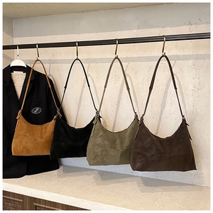 Detailed display of four retro shoulder bags in caramel, black, green and brown suede