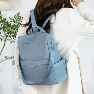 Close-up of light blue fashion backpack featuring textured material and kangaroo logo detail