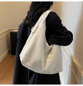 Detail showing white minimalist slouchy shoulder bag with natural wrinkled texture