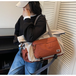 Dettaglio di una borsa da viaggio in tela grande con contrasto arancio e beige e tracolla