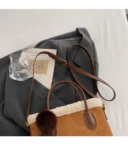 Détail du sac seau en daim marron avec garniture en peau de mouton et sangle réglable