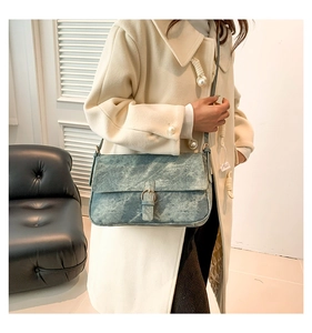 Vue détaillée du sac à bandoulière en similicuir marbré bleu cyan avec boucle dorée