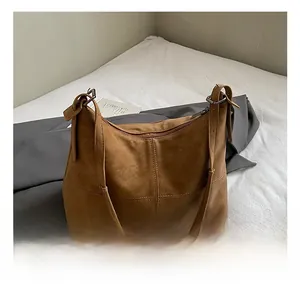 Detail of vintage brown tote bag showing litchi grain texture and adjustable straps