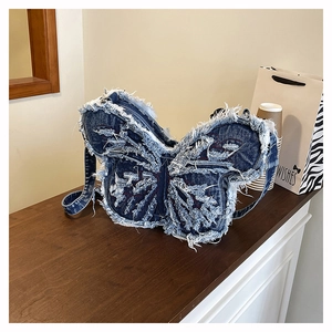 Dettaglio borsa in denim a farfalla con bordi sfrangiati e cuciture rosse a contrasto