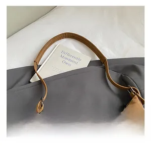 Detail view of brown faux leather hobo bag featuring lychee texture and wide handle