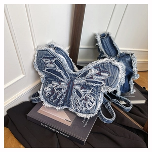 Dettaglio dello zaino a farfalla in denim con bordi sfrangiati e finitura lavata
