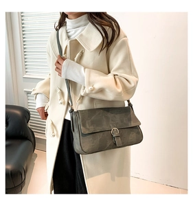 Sac bandoulière rétro gris avec boucle en métal porté pour un style élégant