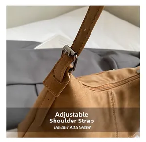 Detail of adjustable shoulder strap with silver buckle on brown vintage tote bag