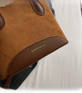 Gros plan sur la texture en daim marron et cuir avec logo doré Fashion & Bags