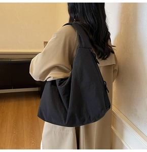 Close-up of minimalist black oversized tote bag with comfortable wide shoulder straps