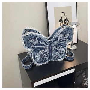 Dettaglio della borsa a farfalla in denim blu lavato con bordi sfilacciati e texture vintage