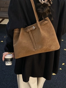 Chic brown suede tote bag for women with silver buckle detail in a street style shot