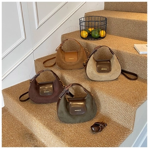 Macro view of retro suede half-moon bags in assorted autumn colors with leather handles