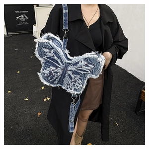 Vista street style di una borsa in denim a forma di farfalla con bordi sfrangiati