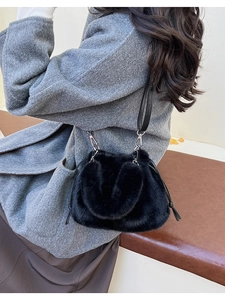 Détail d'un sac seau en fausse fourrure noire avec cordon et crochets métalliques