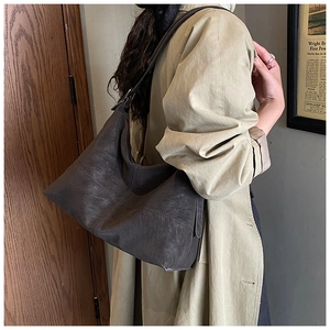 Detail view of large dark brown leather tote bag showing texture and adjustable strap