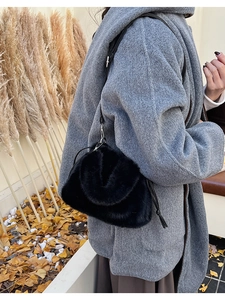 Détail du sac seau en fausse fourrure noire avec texture douce et bandoulière en cuir