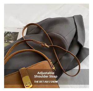 Detail of retro brown leather bucket bag with adjustable strap and golden magnetic clasp