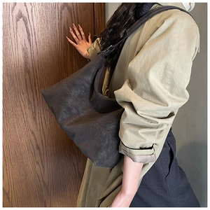 Detail of vintage coffee brown tote bag showing textured faux leather and wide strap