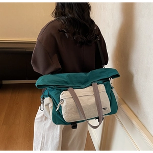Dettaglio della borsa da viaggio capiente in nylon con design a contrasto e tracolla