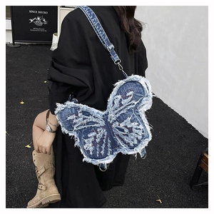 Dettaglio dello zaino a farfalla in denim blu con bordi sfrangiati e cuciture rosse