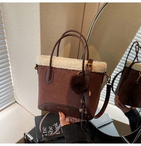 Détail du sac à main en daim marron avec bordure en peau lainée et pompon en peluche