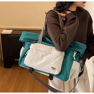 Dettaglio della grande borsa da viaggio in nylon con tracolle regolabili e tessuto a contrasto