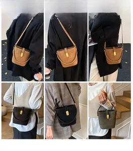 Drei matte Leder-Eimertaschen in verschiedenen Farben getragen von einem Modell