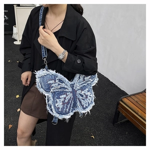 Dettaglio borsa a farfalla in denim con bordi sfrangiati e ricamo rosso sulla modella
