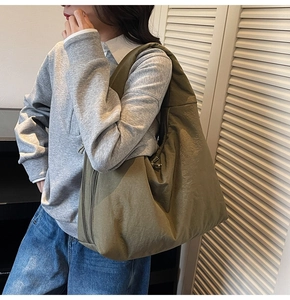 Detail showing the olive green tote bag side zipper and textured fabric for daily use