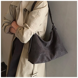 Close-up of dark grey leather hobo bag with vintage texture and brown shoulder strap