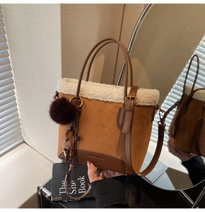 Détail du sac en daim marron avec bordure en fausse fourrure blanche et sangle