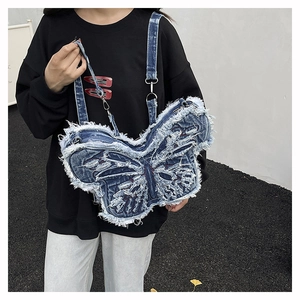 Dettaglio dello zaino a farfalla in denim con bordi sfrangiati bianchi e fibbia in metallo