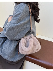 Détail d'un sac seau en fausse fourrure rose avec cordon et bandoulière en cuir brun