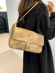Sac bandoulière rétro marron en suédine avec boucle métallique sur manteau noir