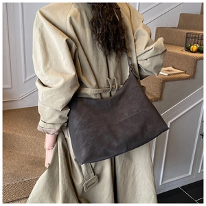 Close-up of matte dark brown Hobo bag with visible cross-stitching and adjustable strap