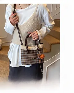 Detail of wool bucket bag featuring houndstooth pattern and faux shearling trim