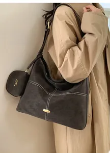 Detail of dark coffee suede tote with contrast stitching and small attached pouch