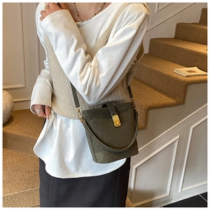 Detailansicht der olivgrünen Beuteltasche mit Goldschnalle und verstellbarem Riemen