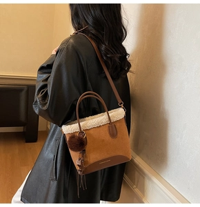 Vue détaillée du sac cabas en daim marron avec bordure en polaire et pompon doux