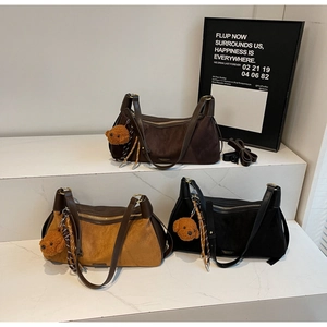 Trois élégants sacs à bandoulière en fini mat café, kaki et noir sur plateforme blanche