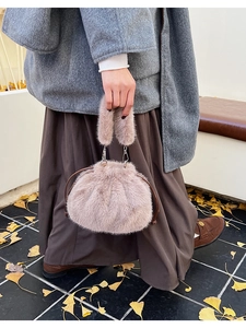 Détail de la texture en fausse fourrure d'un sac seau à cordon avec ferrures métalliques