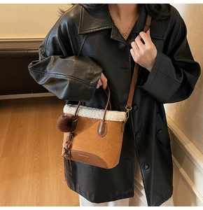 Détail d'un sac vintage marron avec bordure en peluche blanche et pendentif pompon chic