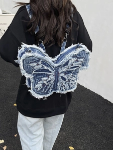 Zaino in denim a forma di farfalla con bordi sfrangiati indossato da modella