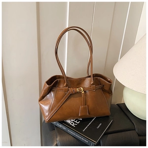 Close-up of brown PU leather tote bag with decorative buckle and gold hardware detail