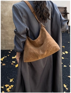 Close-up of vintage brown suede tote bag with cross stitching detail on hobo style bag