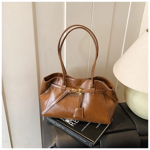 Detail view of brown vintage leather tote bag with elegant buckle and stitching