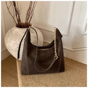 Detail of dark brown suede Hobo bag with white contrast stitching and gold chain